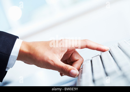 Close-up femmina del dito indice sul pulsante bianco della tastiera del computer Foto Stock