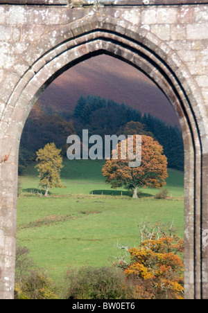 Vista attraverso il passaruota Llanthony Priory agli alberi di colore di autunno Monmouthshire South Wales UK Foto Stock