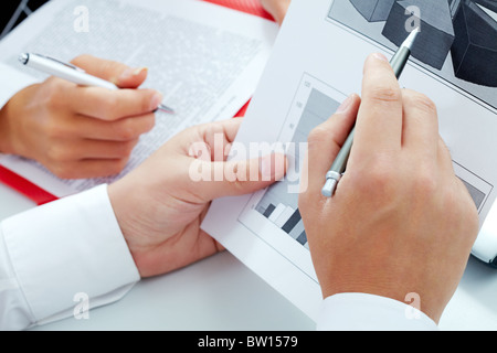 Close-up di imprenditore di puntamento a mano a schema durante la discussione Foto Stock