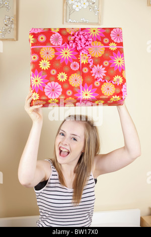 Una ragazza adolescente apre regali di compleanno in camera sua REGNO UNITO Foto Stock