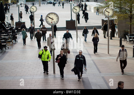 Orologi al di fuori di canary wharf stazione con i lavoratori della città , sei orologi pubblici, Konstantin Grcic, scultura, acciaio, vetro Foto Stock