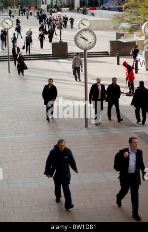 Orologi al di fuori di canary wharf stazione con i lavoratori della città , sei orologi pubblici, Konstantin Grcic, scultura, acciaio, vetro Foto Stock