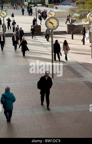 Orologi al di fuori di canary wharf stazione con i lavoratori della città , sei orologi pubblici, Konstantin Grcic, scultura, acciaio, vetro Foto Stock