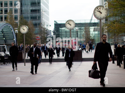 Orologi al di fuori di canary wharf stazione con i lavoratori della città , sei orologi pubblici, Konstantin Grcic, scultura, acciaio, vetro Foto Stock