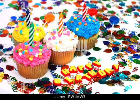 Tortini di compleanno con candele e spruzza. Coriandoli e ventose in background. Foto Stock