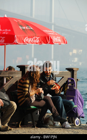 ISTANBUL, Turchia. Una giovane coppia turca di mangiare cibo da asporto dal Bosforo a Ortakoy mercato, distretto di Besiktas. 2010. Foto Stock