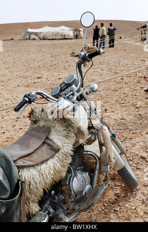 Motocicletta in corrispondenza di un accampamento beduino nel deserto siriano. Foto Stock