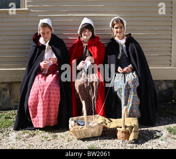 Tre giovani donne, vestito in costume, sedersi a Strawbery Banke Museum, Portsmouth, STATI UNITI D'AMERICA Foto Stock