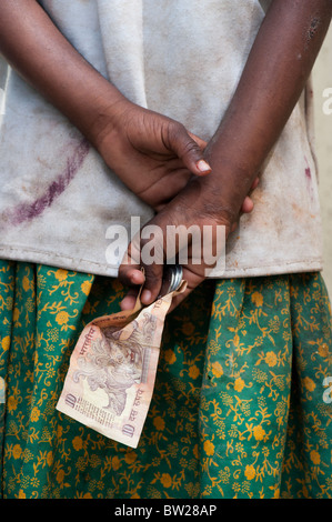 Indiano ragazza di strada mendicando per denaro, tenendolo dietro la schiena. Andhra Pradesh, India Foto Stock