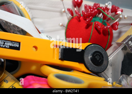 Una selezione di accessori per il cucito e merceria in un sarti box pronto per l'uso da una sarta intenti sulla progettazione e la cucitura Foto Stock