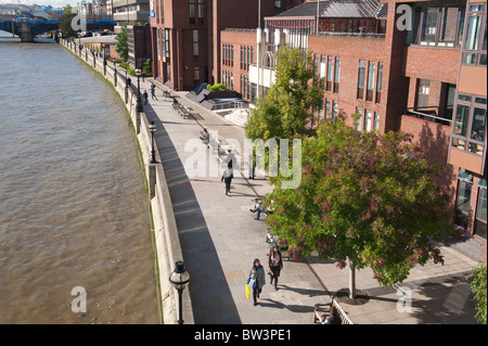 Gruppo di persone a piedi lungo la North Embankment Paolo a piedi London illustrante la barriera antiesondazione sistema di difesa Foto Stock