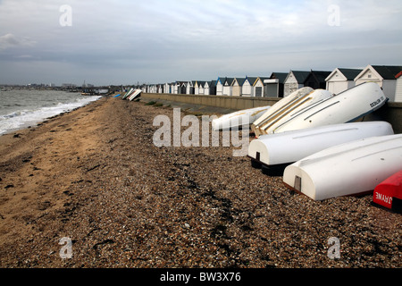 Spiaggia di sabbia e ciottoli con capanne e gommoni a Southend in Essex fuori stagione Foto Stock