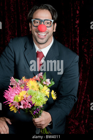 La metà di età compresa tra uomo, vestito in abito formale agisce come un clown Foto Stock