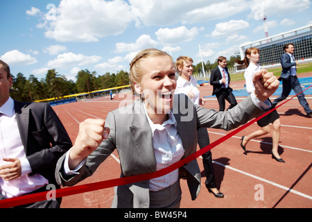 Foto di felice imprenditrice Attraversamento linea di finitura durante la gara Foto Stock