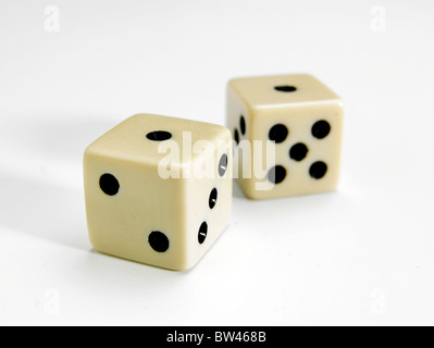 Una coppia di selettivamente concentrati white dice che mostra uno alla parte superiore su sfondo bianco Foto Stock