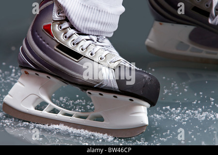 Close-up di pattini sul lettore piedi durante l'hockey su ghiaccio Foto Stock