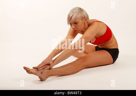 I giovani alla moda donna fit stretching fuori i suoi muscoli delle gambe Foto Stock