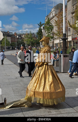 Una femmina di silent street performer nella lunga fila Nottingham Foto Stock