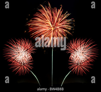 Tre raffiche di rosso bianco e oro fuochi d'artificio contro un nero lo sfondo di notte Foto Stock