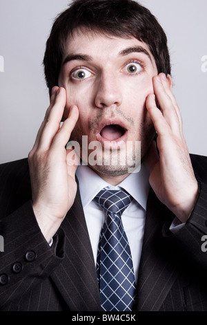 Divertente Ritratto di giovane stupito uomo d affari Foto Stock