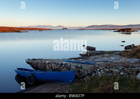 Barca da pesca legato accanto Glenicmurrin Lough, Connemara, nella contea di Galway, Connaught, Irlanda. Foto Stock