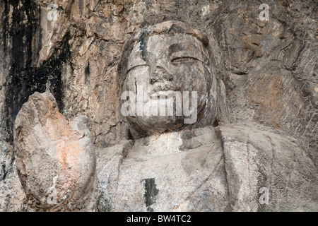 Una pietra scolpita Buddha, scavate nella roccia, le Grotte di Longmen e grotte, Luoyang, nella provincia di Henan, Cina Foto Stock