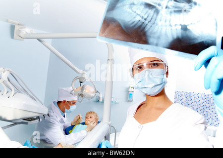 Ritratto di assistente alla ricerca al paziente' x-ray fotografia durante esame dentale Foto Stock