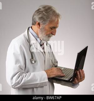 Coppia medico con laptop, indossando uno stetoscopio e bianco camice, 9 novembre 2010, © Katharine Andriotis Foto Stock