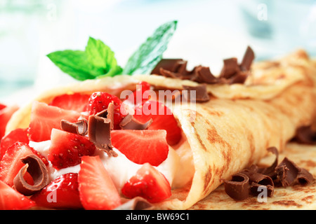 Crepes con formaggio e fragole cosparso con i riccioli di cioccolato Foto Stock