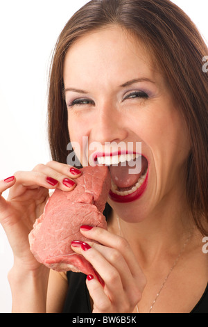 Bella Donna morde un pezzo grezzo di carni bovine Foto Stock