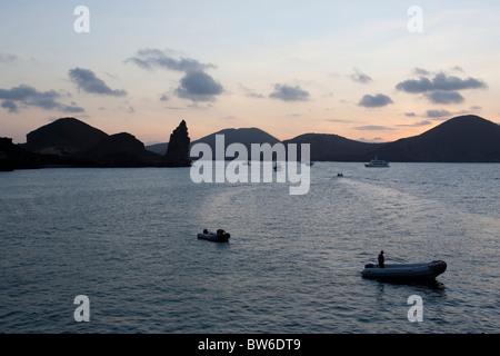 Vista del pinnacolo di roccia, tour ormeggiate barche e, zodiacs al tramonto, Bartolome Island, Galapagos. Foto Stock