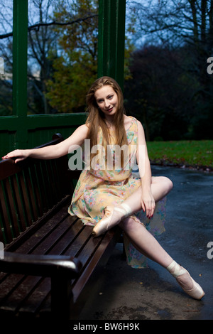 Ritratto completo di una ballerina seduto su una panca con scarpe a punta, Waterlow Park, N6, Highgate, Londra, Inghilterra, Regno Unito Foto Stock