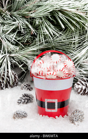 Un secchio decorativo di caramella di Natale in un deserto nevoso. Aprire lo spazio per copiare intenzionalmente lasciata nella parte superiore dell'immagine area della struttura ad albero. Foto Stock