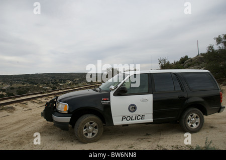 Una marcata railroad veicoli della polizia si erge, parcheggiata vicino al deserto remoto brani. Foto Stock