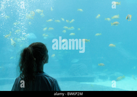 Ragazza la visione di pesce in uno dei tanti grandi vasche acquari all'Atlantis Resort Bahamas Foto Stock