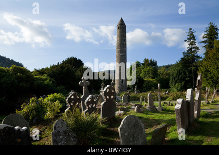 Torre rotonda e cimitero di Glendalough Inizio sito monastico, County Wicklow, Irlanda Foto Stock