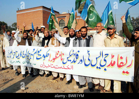 Gli attivisti del Jamat-e-Islami chant slogan contro riformato la GST e la tassa alluvione durante una manifestazione di protesta a Peshawar Foto Stock