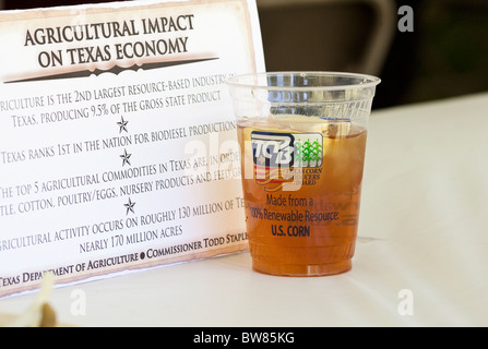 Mais biodegradabile tazza di plastica fatta di polilattide (PLA) riempito con tè freddo sul piano portapaziente Foto Stock