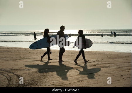 Surfers passeggiate a mare a Condino Devon UK Foto Stock