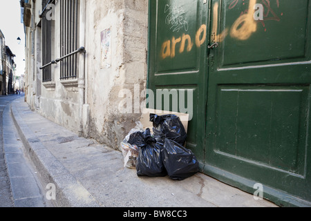 Spazzatura impilati al di fuori di una porta in una strada in Avignon Vaucluse, Francia. Foto Stock