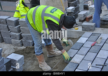 Workman posa di nuova pavimentazione di pietra, Carnaby Street, Soho, West End, la City of Westminster, Greater London, England, Regno Unito Foto Stock