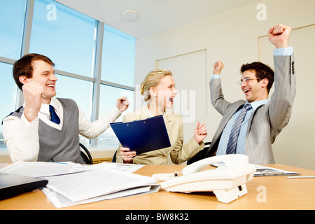 Immagine di persone di successo alzando le mani e crematura in ufficio Foto Stock