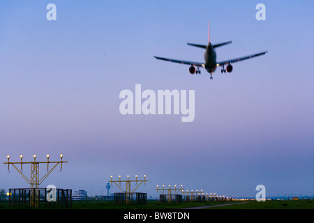 Aeroporto Schiphol di Amsterdam al crepuscolo. Piano aereo di avvicinamento e di atterraggio, sulla pista Kaagbaan. Foto Stock