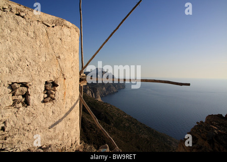 Vista di mulino a vento che si affaccia sul Mar Egeo da Olympos borgo montano in Karpathos isola del mar Egeo, Grecia Foto Stock