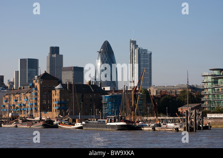 Thames tradizionale vela chiatte sul fiume Tamigi, a Londra; skyline della città dietro, compreso il Gherkin (30 St Mary Axe) Foto Stock