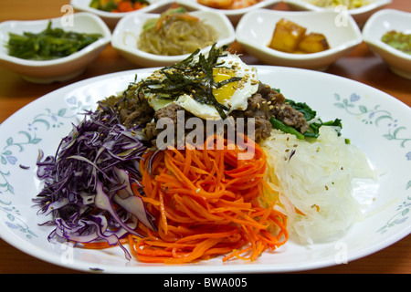 Un popolare coreano piatto Bibimbap, significa mescolare il riso condito con verdure condita, peperoncino, uova fritte e fette di carne di manzo Foto Stock