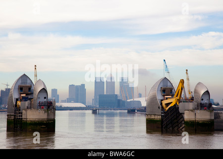 Thames Flood Barrier, Woolwich, Londra, Regno Unito. Canary Wharf in background. Foto Stock