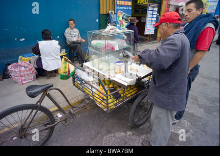 L'uomo vendita di succo di frutta appena spremuto da triciclo stand, Lima, Peru Foto Stock