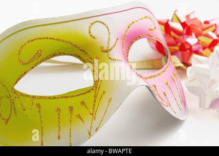 Maschera di carnevale e archi colorati su sfondo bianco Foto Stock