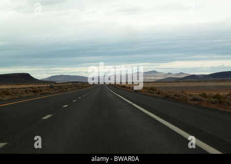 La guida su un lungo tratto di autostrada vuota nel nord del Nevada USA Foto Stock